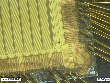 Área con una partícula extraña en un chip de CI (200x)